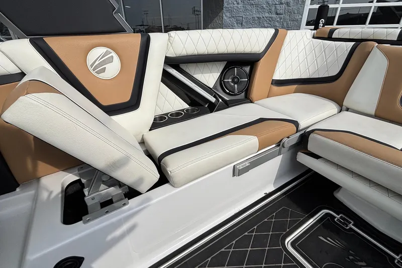 Slide: The Image of 2021 Tigé 25ZX boat interior with luxurious tan and white seating, featuring cup holders and speaker. - 51