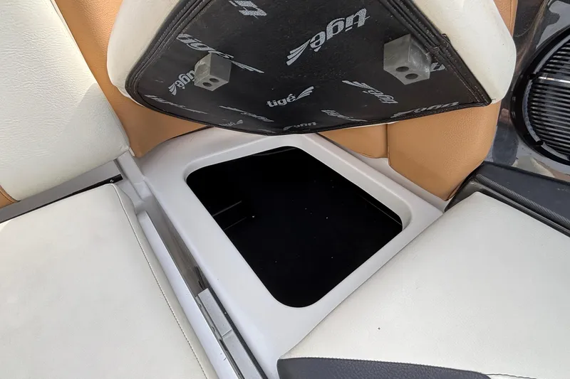 Slide: The Image of 2021 Tigé 25ZX boat interior storage compartment with open seat cushion. - 54