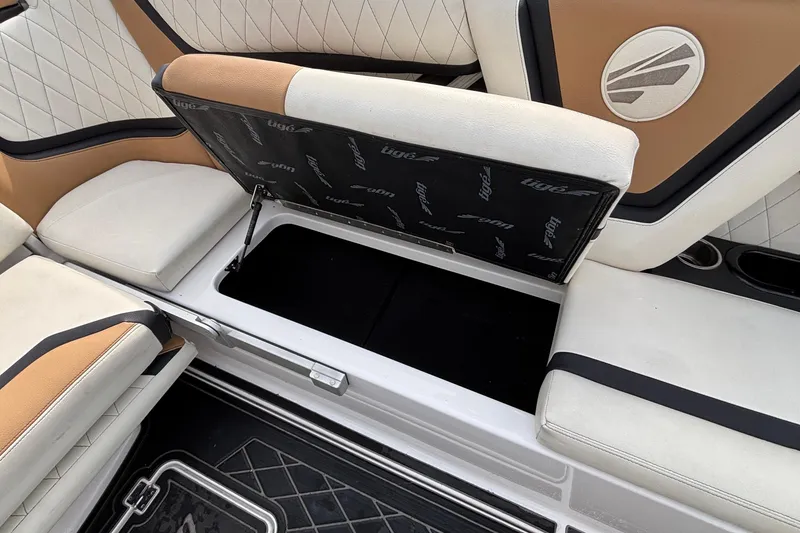 Slide: The Image of 2021 Tigé 25ZX boat interior with open storage compartment and cushioned seating. - 55