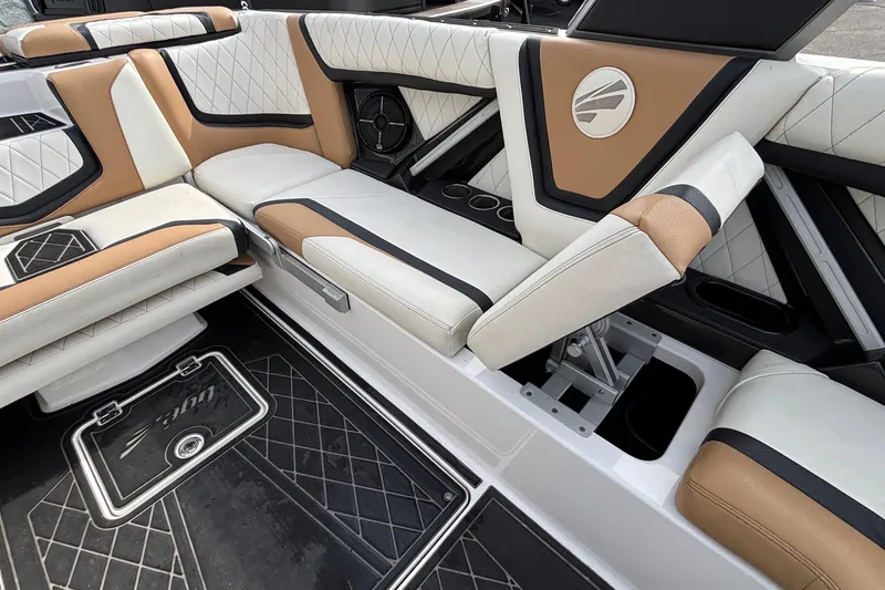 Slide: The Image of 2021 Tigé 25ZX boat interior with luxurious tan and white seating, featuring cup holders. - 56