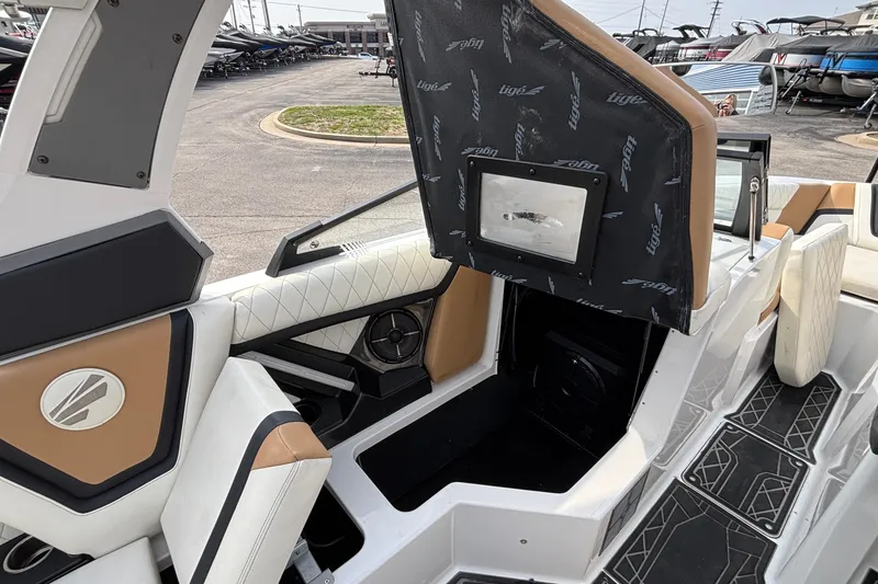 Slide: The Image of 2021 Tigé 25ZX boat interior with open storage compartment and stylish seating. - 57
