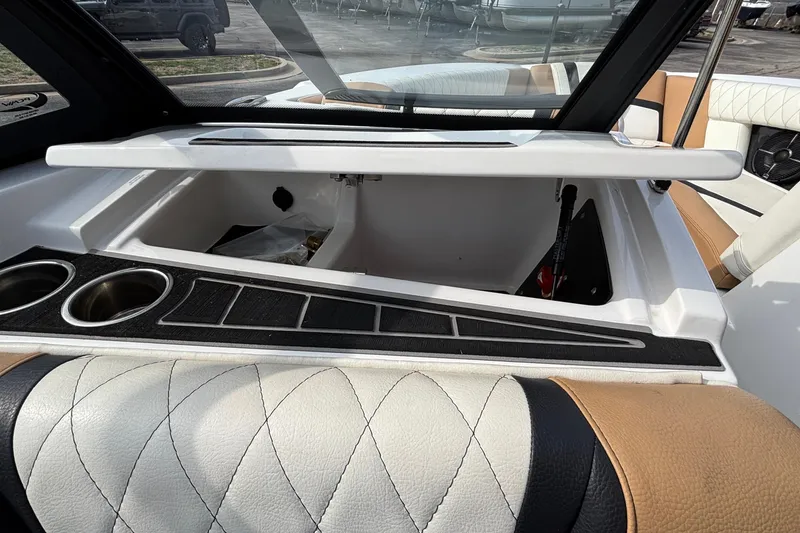 Slide: The Image of 2021 Tigé 25ZX boat interior with storage compartment and cup holders. - 58