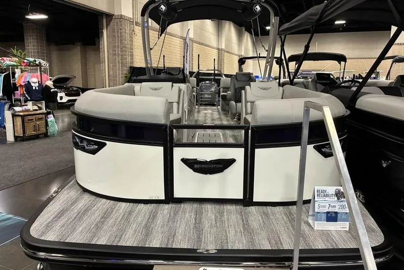 The Image of 2025 Bennington LX Sport Quad Bench 24 LXSFBA pontoon boat displayed indoors. - 1