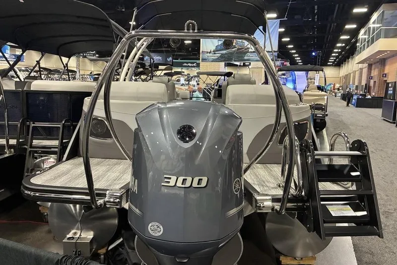 Slide: The Image of 2025 Bennington LX Sport Quad Bench 24 LXSFBA pontoon boat with Yamaha 300 engine at a boat show. - 5