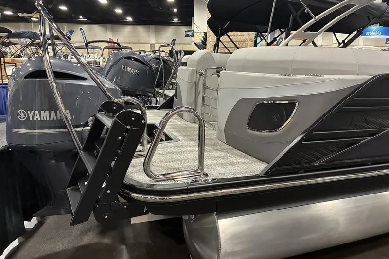 Slide: The Image of 2025 Bennington LX Sport Quad Bench 24 LXSFBA pontoon boat with Yamaha engine at a boat show. - 6