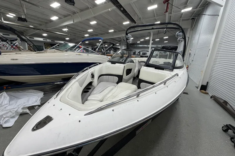 Slide: The Image of 2004 Malibu Wakesetter 23 LSV boat in showroom, featuring sleek white design and spacious seating. - 3