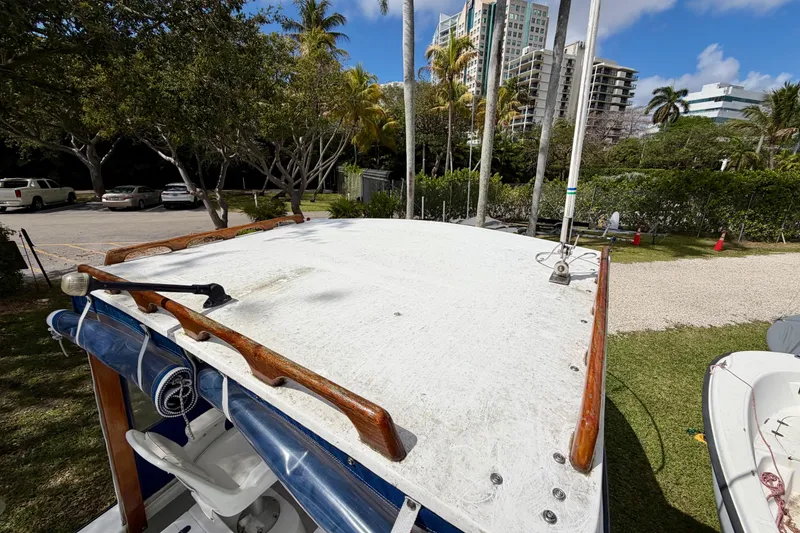 Slide: The Image of 2000 Eastern 22 Lobster Fisherman boat on grass, surrounded by trees and buildings. - 11