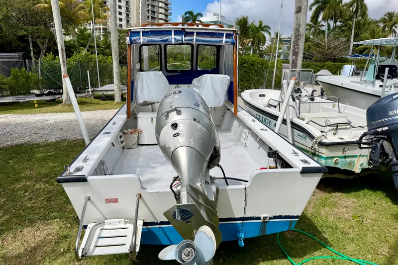 Slide: The Image of 2000 Eastern 22 Lobster Fisherman boat with outboard motor, parked on grass near other boats. - 4
