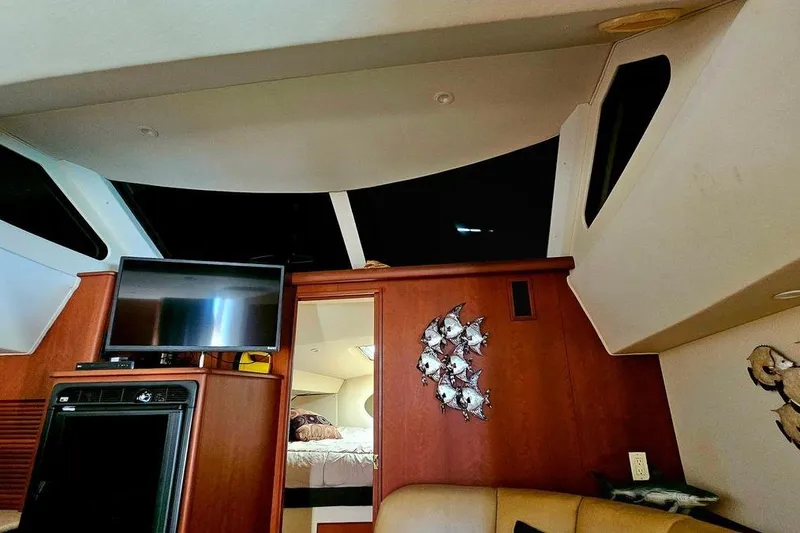 Slide: The Image of Interior of 2005 Silverton 330 Sport Bridge with TV, wooden cabinetry, and decorative wall art. - 12