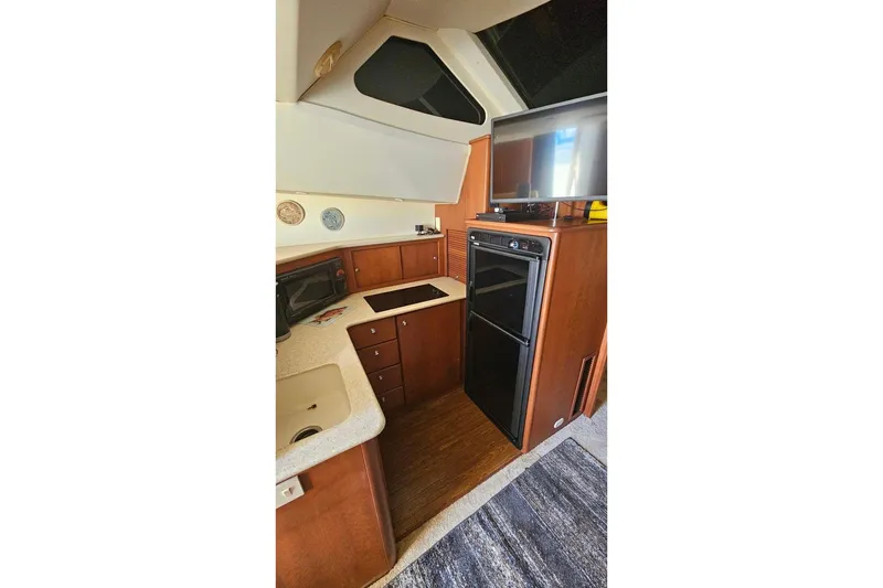 Slide: The Image of 2005 Silverton 330 Sport Bridge yacht interior kitchen with modern appliances and wood cabinetry. - 14