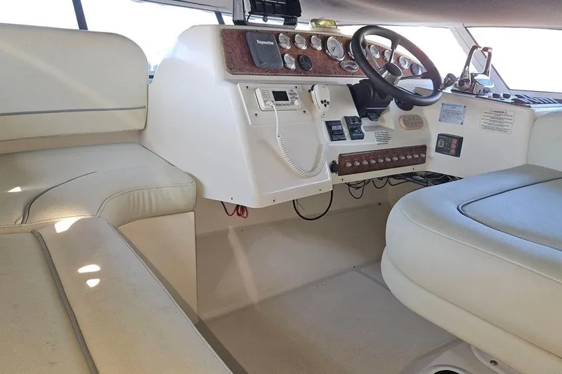Slide: The Image of 2005 Silverton 330 Sport Bridge helm with beige seating and control panel. - 18