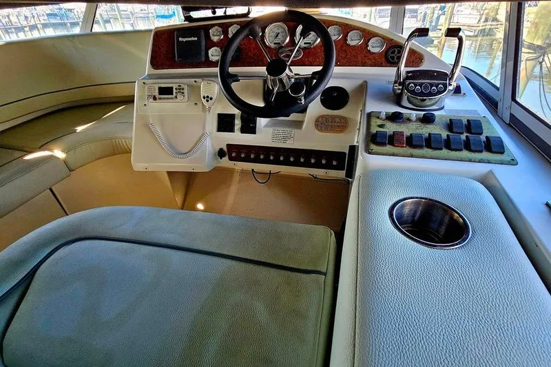 Slide: The Image of 2005 Silverton 330 Sport Bridge helm with steering wheel, controls, and seating area. - 20