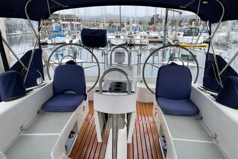 Slide: The Image of Cockpit of 2005 Catalina 470 sailboat with blue seating and wooden flooring in a marina. - 12