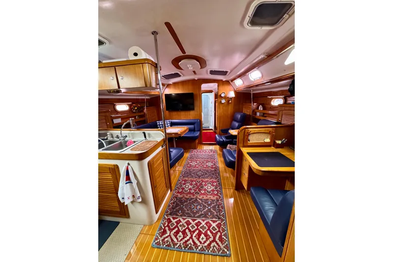 Slide: The Image of Interior of a 2005 Catalina 470 yacht with wood finishes and blue seating. - 13