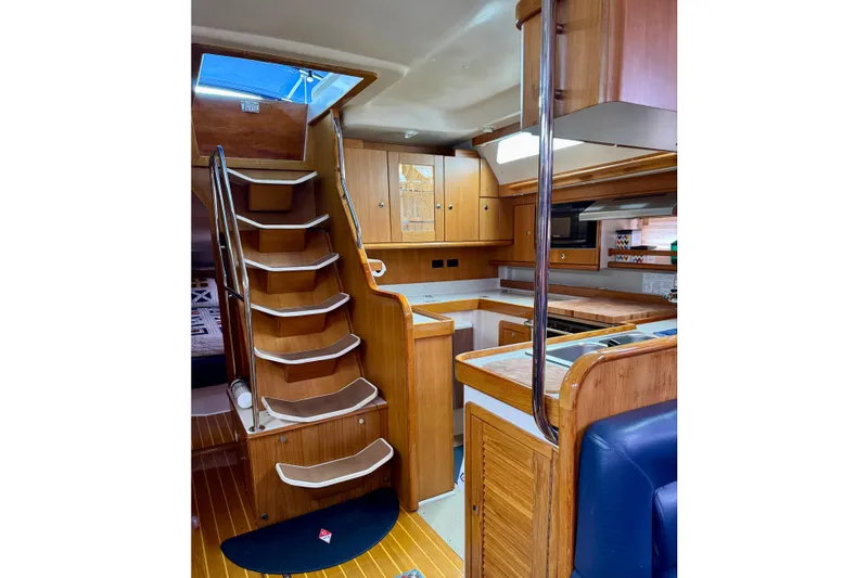 Slide: The Image of Interior of 2005 Catalina 470 sailboat with wooden cabinetry and staircase. - 14