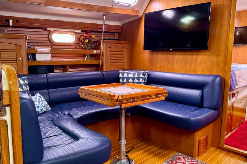 Slide: The Image of Luxurious 2005 Catalina 470 yacht interior with blue leather seating and wooden accents. - 18