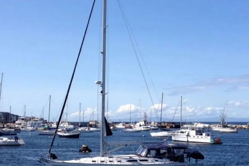 Slide: The Image of Sailboats in a marina, featuring a 2005 Catalina 470 under a clear blue sky. - 2