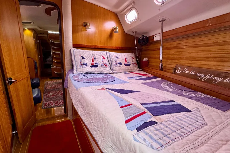 Slide: The Image of Cozy cabin interior of 2005 Catalina 470 sailboat with nautical-themed bedding. - 23
