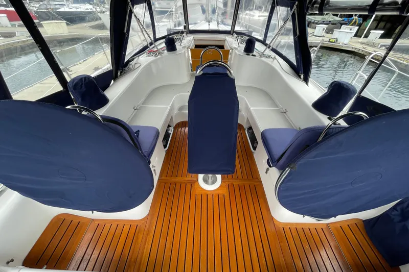 Slide: The Image of 2005 Catalina 470 yacht cockpit with blue covers and wooden flooring at marina. - 3