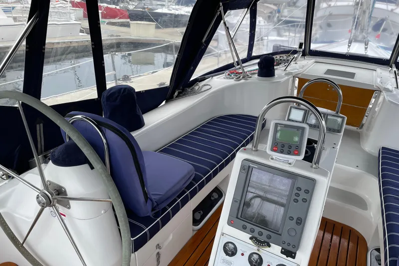 Slide: The Image of Cockpit of a 2005 Catalina 470 sailboat with navigation equipment and striped seating. - 6