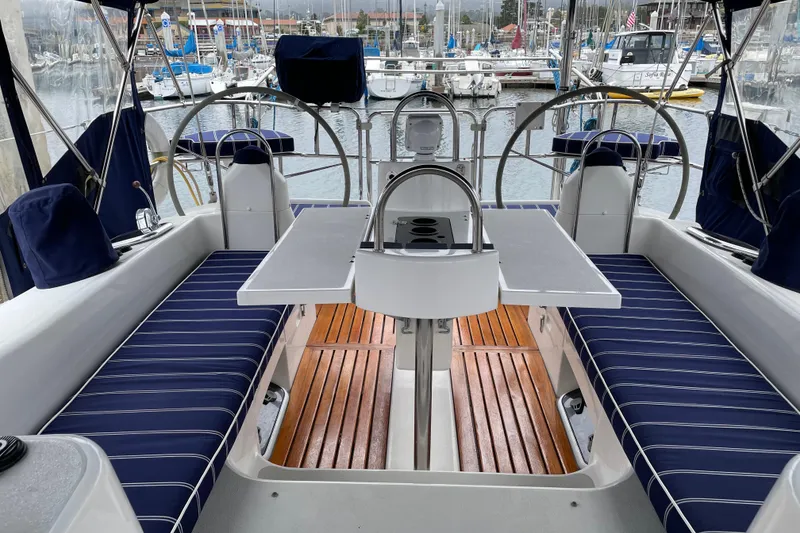 Slide: The Image of 2005 Catalina 470 sailboat cockpit with striped seating and marina view. - 7