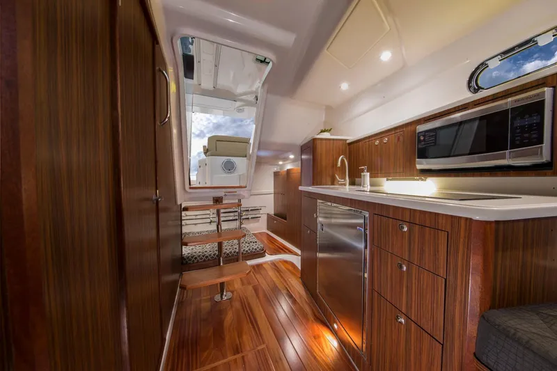 Slide: The Image of Manufacturer Provided Image: 2016 Pursuit OS 355 Offshore yacht interior with modern kitchen and cozy sleeping area. - 6