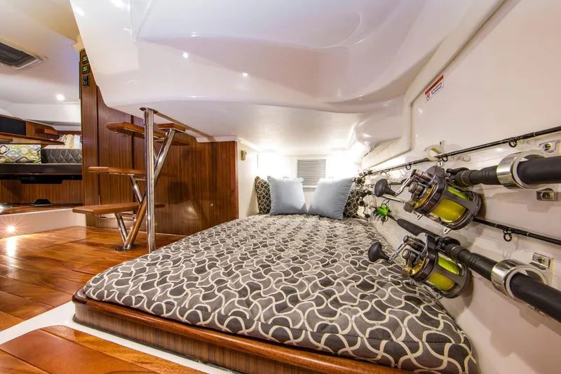 Slide: The Image of Manufacturer Provided Image: 2016 Pursuit OS 355 Offshore cabin interior with bed and fishing rods. - 7