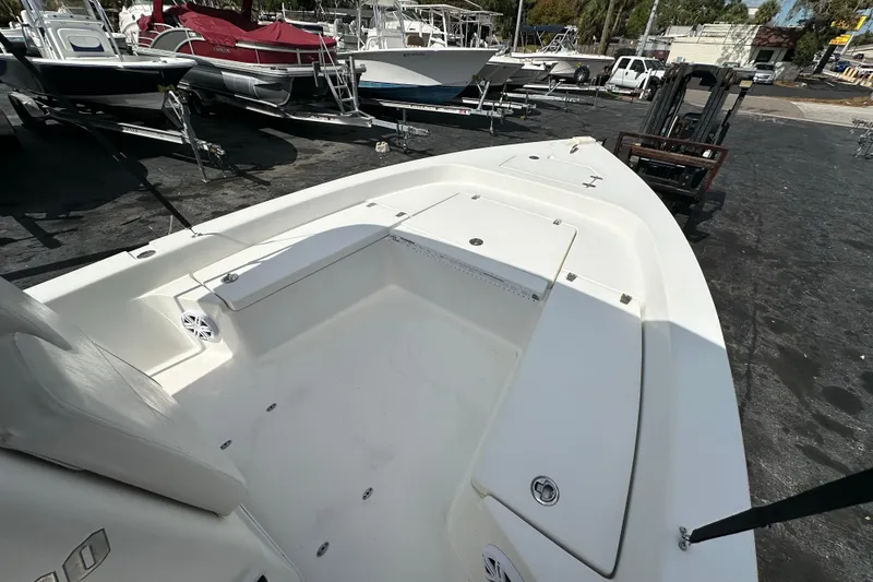 Slide: The Image of 2012 Pathfinder 2200 V boat interior with seating and storage, parked among other boats. - 10