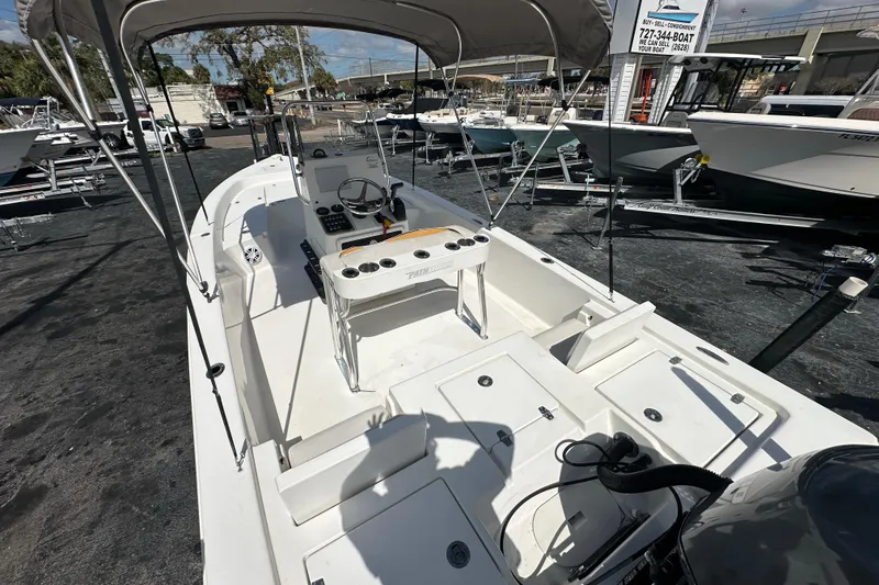 Slide: The Image of 2012 Pathfinder 2200 V boat with canopy, docked at a marina under clear skies. - 18