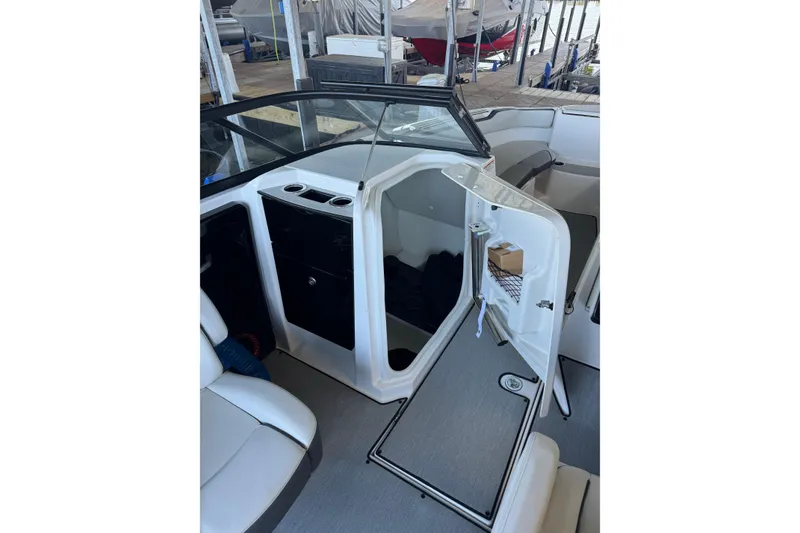 Slide: The Image of 2024 Yamaha Boats AR250 interior with open storage compartment and seating area. - 5
