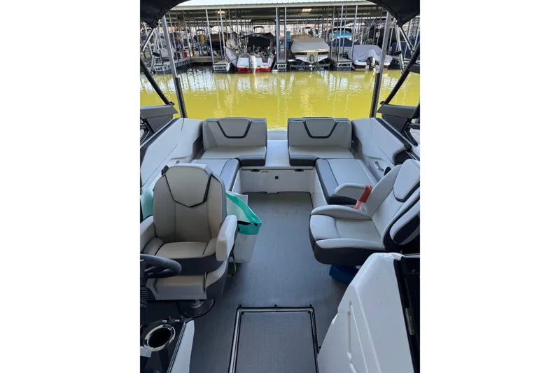 Slide: The Image of 2024 Yamaha Boats AR250 interior with modern seating and dock view. - 8