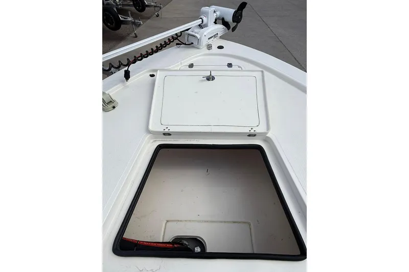 Slide: The Image of 2024 Mako 18 LTS boat deck with open storage compartment and trolling motor. - 11