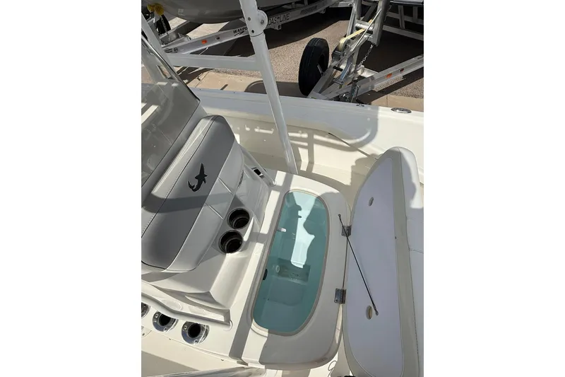 Slide: The Image of 2024 Mako 18 LTS boat interior with open storage compartment and seating. - 13