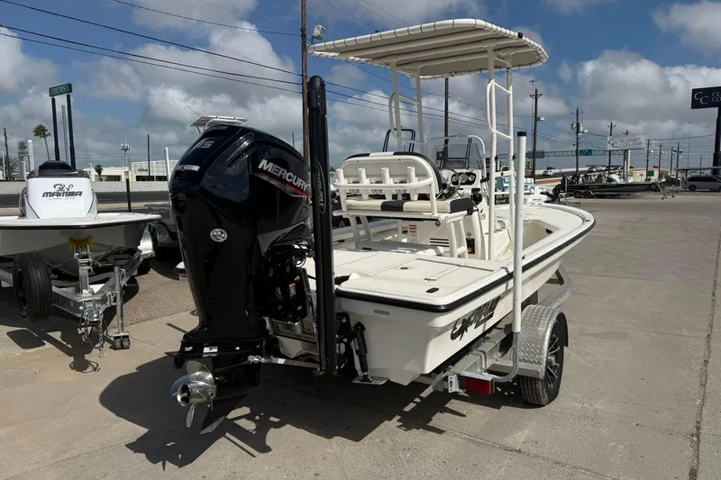 Slide: The Image of 2024 Mako 18 LTS boat with Mercury engine on a trailer, parked outdoors. - 2