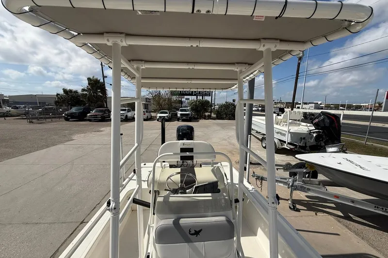 Slide: The Image of 2024 Mako 18 LTS boat with T-top, parked outdoors on a sunny day. - 4