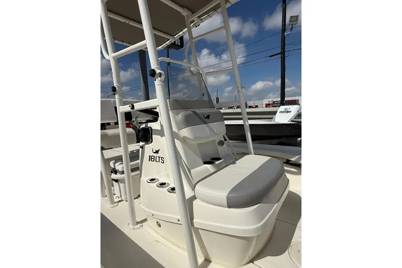 Slide: The Image of 2024 Mako 18 LTS boat interior with seating and console, under a clear blue sky. - 5