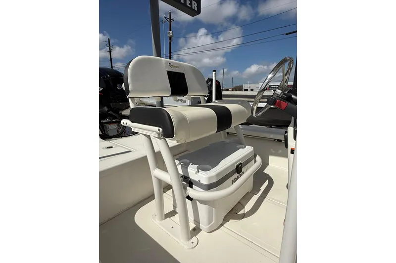 Slide: The Image of 2024 Mako 18 LTS boat interior with seating and steering wheel under a clear sky. - 7