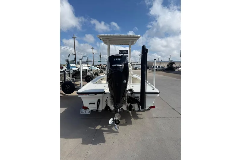 Slide: The Image of 2024 Mako 18 LTS boat with outboard motor, parked outdoors under a blue sky. - 8