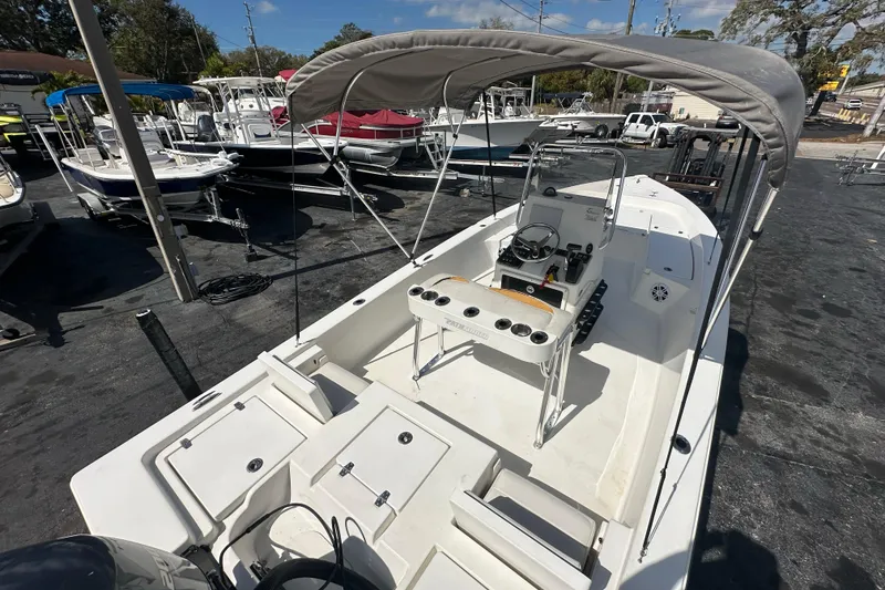 Slide: The Image of 2012 Pathfinder 2200 TRS boat with canopy, parked in a marina under clear skies. - 19
