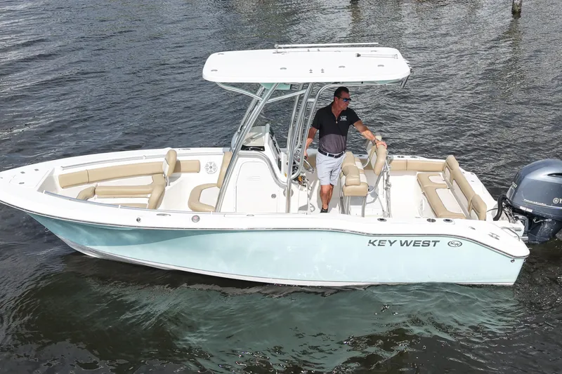 Slide: The Image of 2018 Key West 219 FS boat on water with a person at the helm. - 13