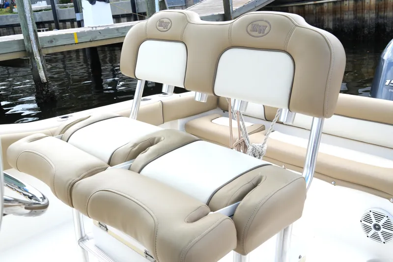 Slide: The Image of 2018 Key West 219 FS boat with tan and white cushioned seating by the dock. - 29