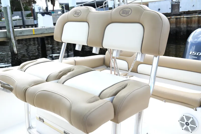 Slide: The Image of 2018 Key West 219 FS boat seats with beige and white upholstery, docked by the water. - 30