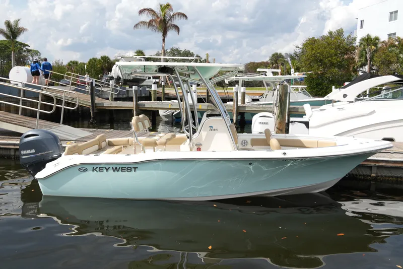 Slide: The Image of 2018 Key West 219 FS boat docked, featuring Yamaha engine, calm water, and marina backdrop. - 40