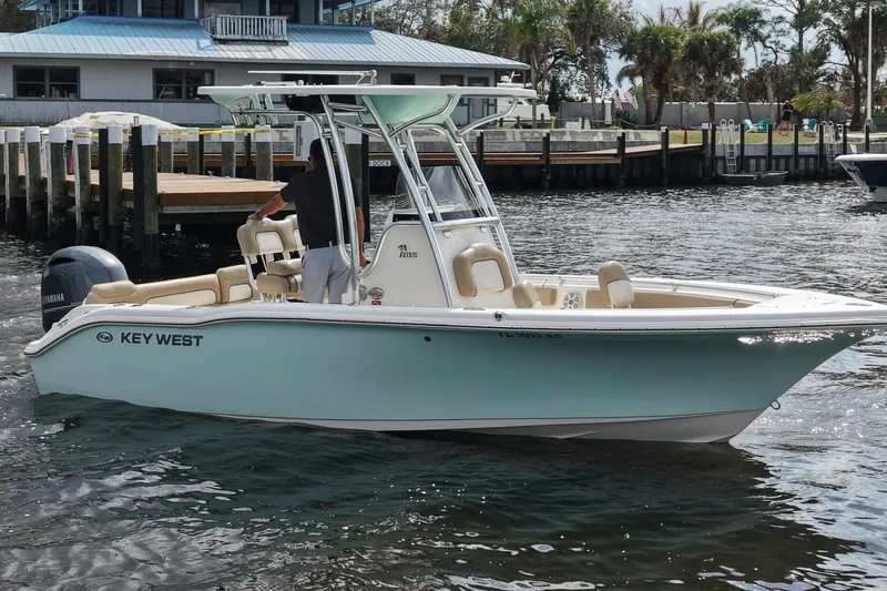 Slide: The Image of 2018 Key West 219 FS boat on water near dock, featuring Yamaha engine. - 5