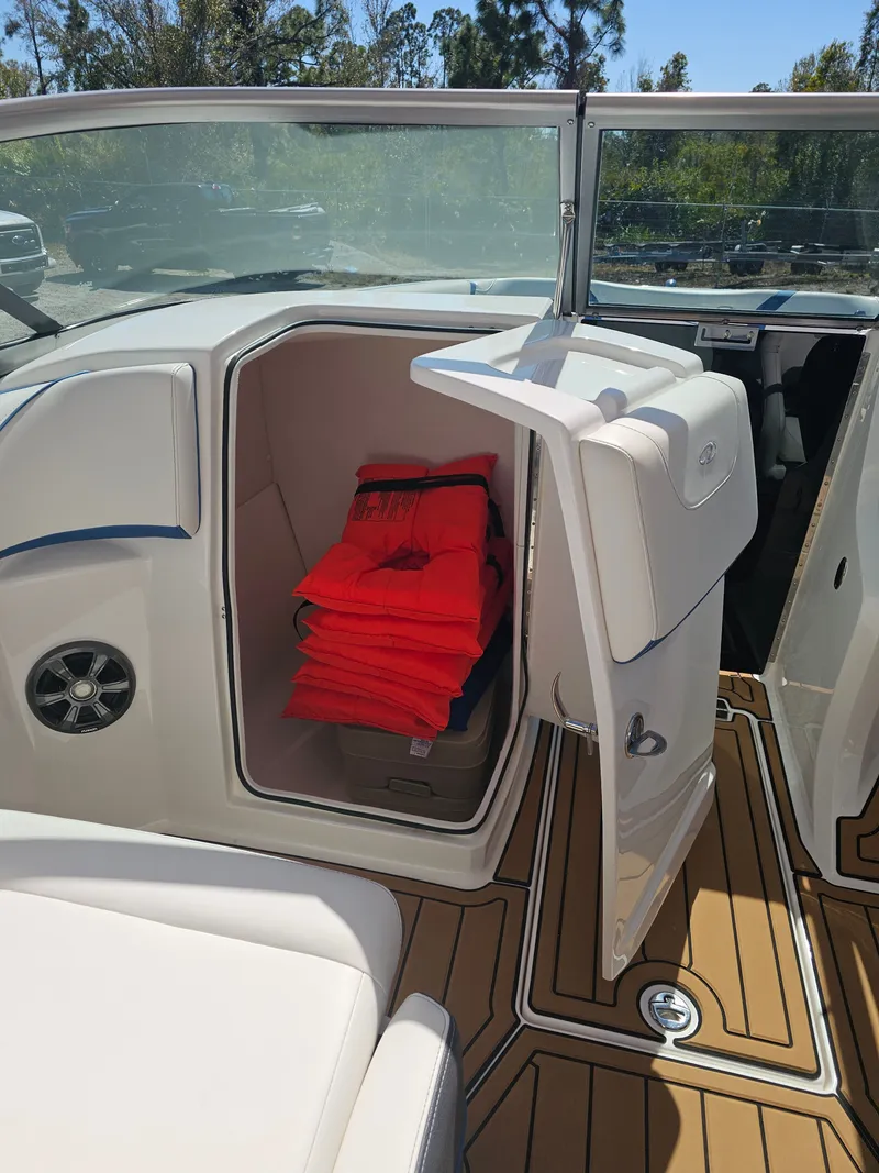 Slide: The Image of 2019 Regal 23 OBX boat with open storage compartment and life jackets. - 16