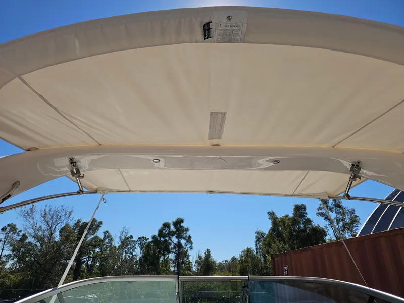 Slide: The Image of Bimini top of a 2019 Regal 23 OBX boat under blue sky. - 30