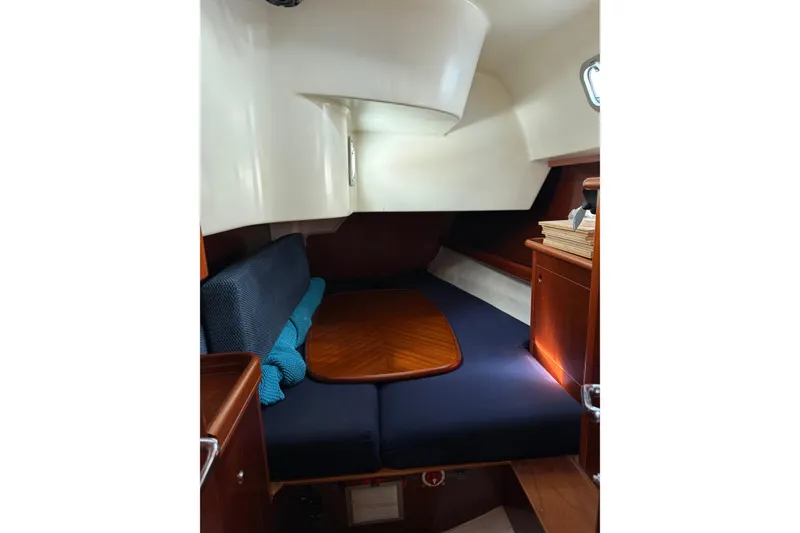 Slide: The Image of Cozy cabin interior of 1997 Beneteau Oceanis 461 sailboat with wooden accents and blue cushions. - 11