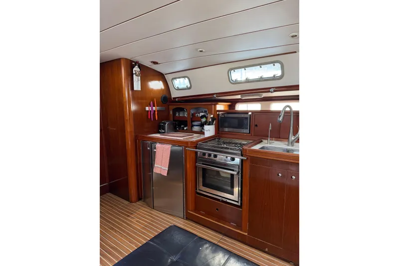 Slide: The Image of Interior of 1997 Beneteau Oceanis 461 yacht kitchen with wood finish and modern appliances. - 14
