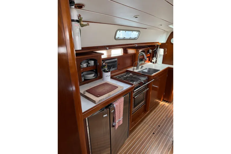 Slide: The Image of Interior view of 1997 Beneteau Oceanis 461 yacht kitchen with wooden cabinetry and modern appliances. - 8