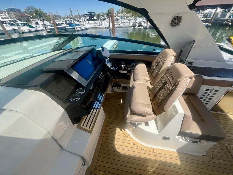 Slide: The Image of 2018 Sea Ray SLX 400 helm with dual seats and modern dashboard, docked at marina. - 5